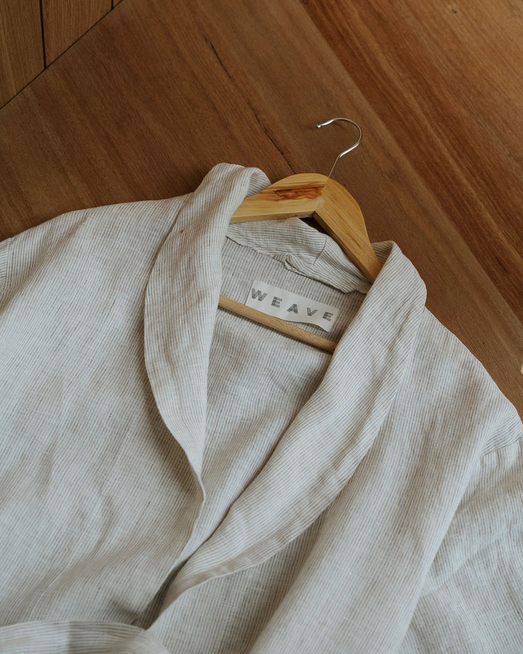 Sova Robe in Savanna, European linen with subtle pinstripe weave, draped on wooden hanger by Weave Home
