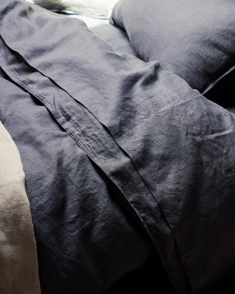 Ravello Fitted Sheet in denim European linen, detail view showing soft prewashed texture and deep side seam, by Weave Home