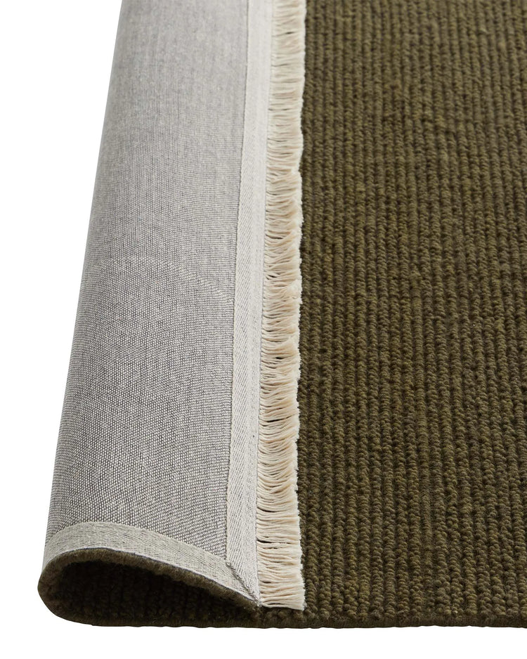 Fabien Moss rug detail showing ribbed wool weave texture with cream fringe edge by Weave Home