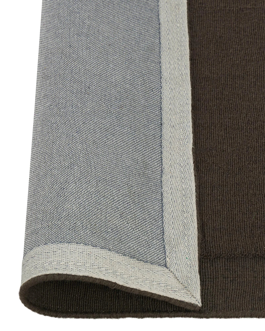 Cassio Fudge rug detail, dark mocha wool with serged edge and lowered border in cream, by Weave Home