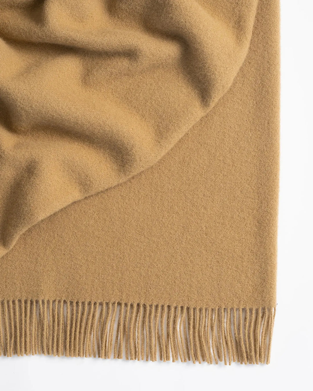 Nevis Camel lambswool throw detail, warm biscuit brown with tassel fringe border by Weave Home