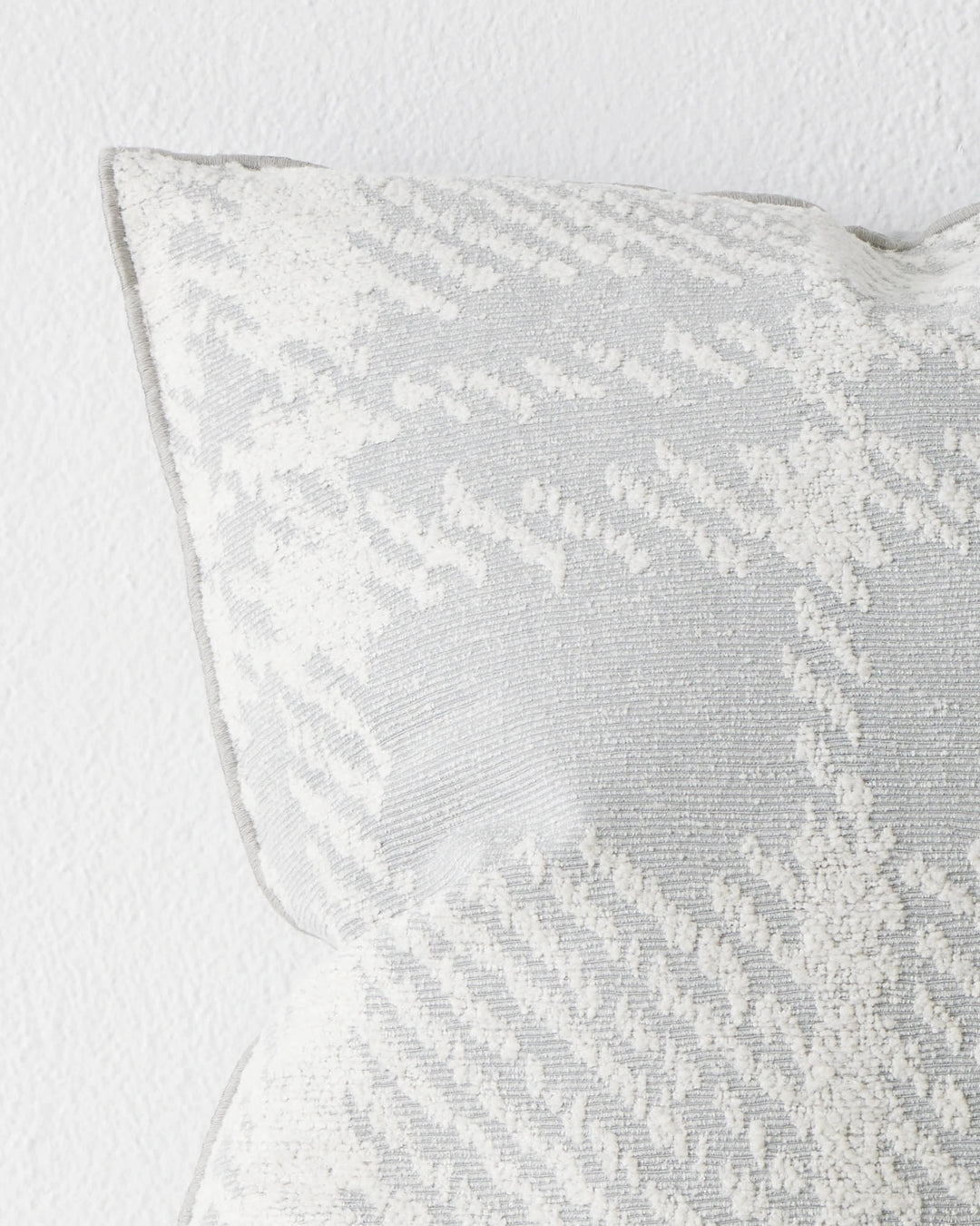Sienne Mist cushion close-up, oversized check pattern in soft white on pale grey polyester cotton blend, overlocked edge detail, by Weave Home