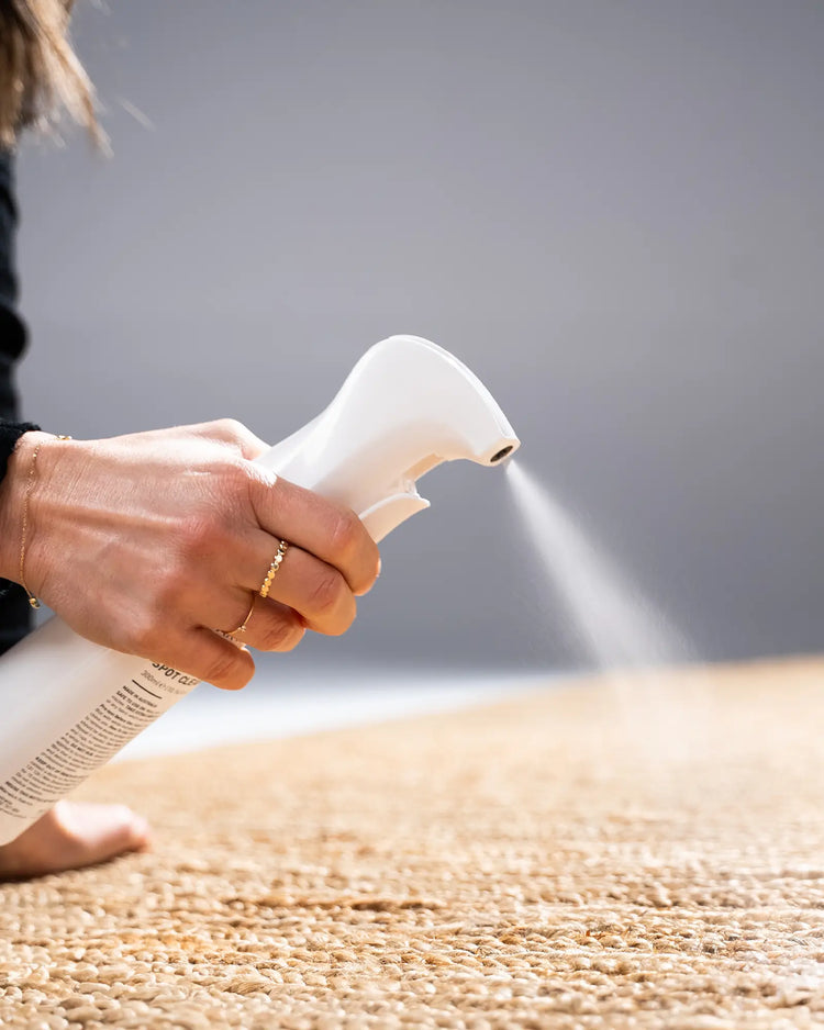 Unmarkable Textile & Rug Spot Cleaner in white bottle, in-use on natural fibre rug by Weave Home