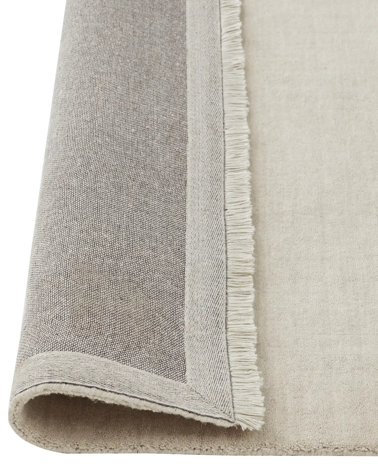 Silvio Ecru rug detail, showing hand-woven texture with micro fringe border and bound edge by Weave Home