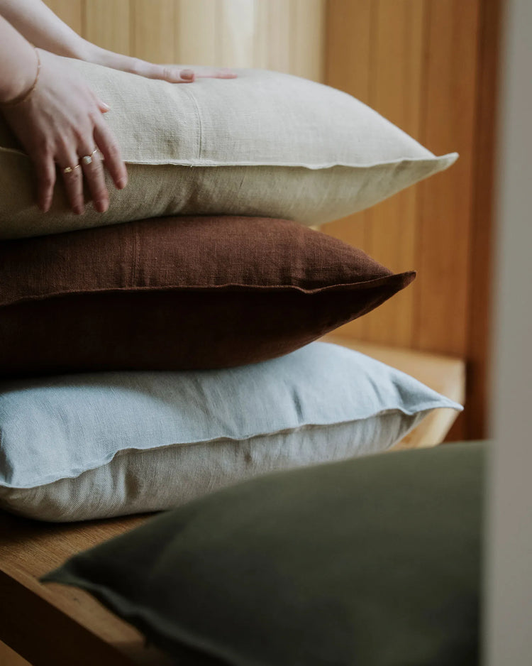 Como linen cushions in Horizon, oatmeal and henna stacked on timber, 100% European linen by Weave Home