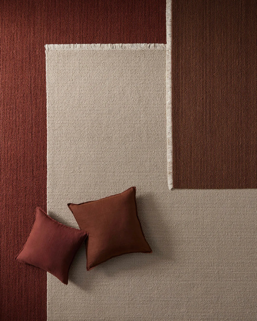 Warm earthy palette with rust and burgundy corduroy walls, cream wool-blend Fabien rug, and matching linen cushions in deep terracotta tones—modern geometric colour blocking styled for interior design and home decor