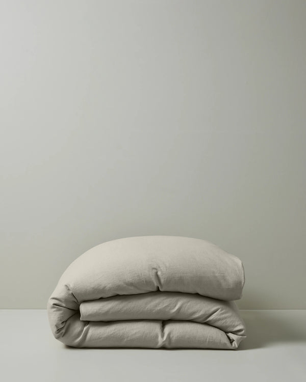 Ravello Quilt Cover in bone European linen, folded to show soft preiwashed texture and relaxed drape, by Weave Home