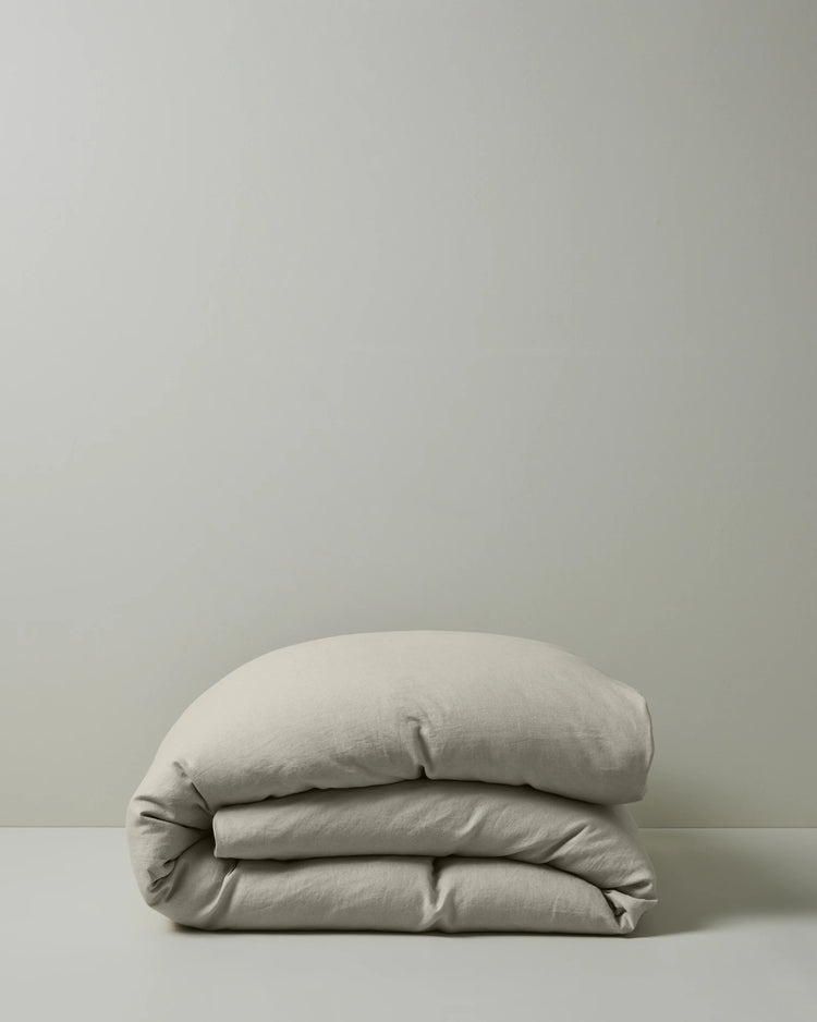 Ravello Quilt Cover in bone European linen, folded to show soft preiwashed texture and relaxed drape, by Weave Home