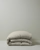 Ravello Quilt Cover in bone European linen, folded to show soft preiwashed texture and relaxed drape, by Weave Home