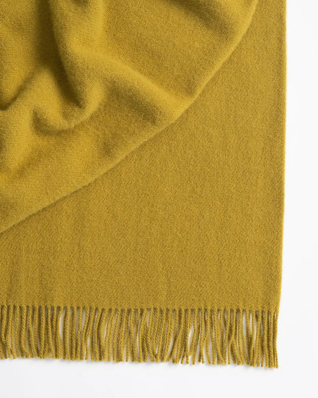 Nevis Chartreuse lambswool throw, vibrant yellow with tassel fringe border detail, by Weave Home