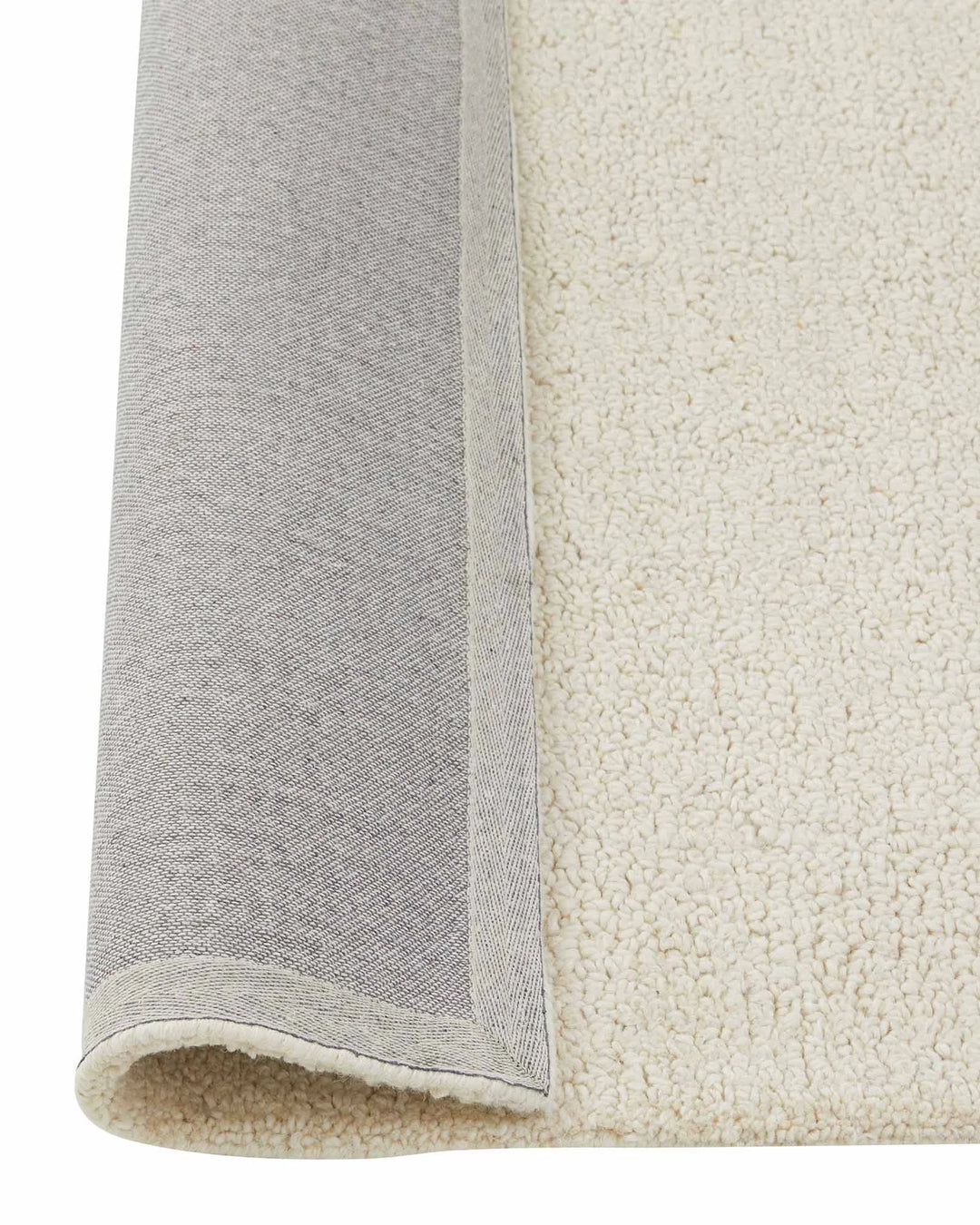 Marceau Angora wool blend rug in cream, rolled detail showing woven texture and grey binding edge by Weave Home