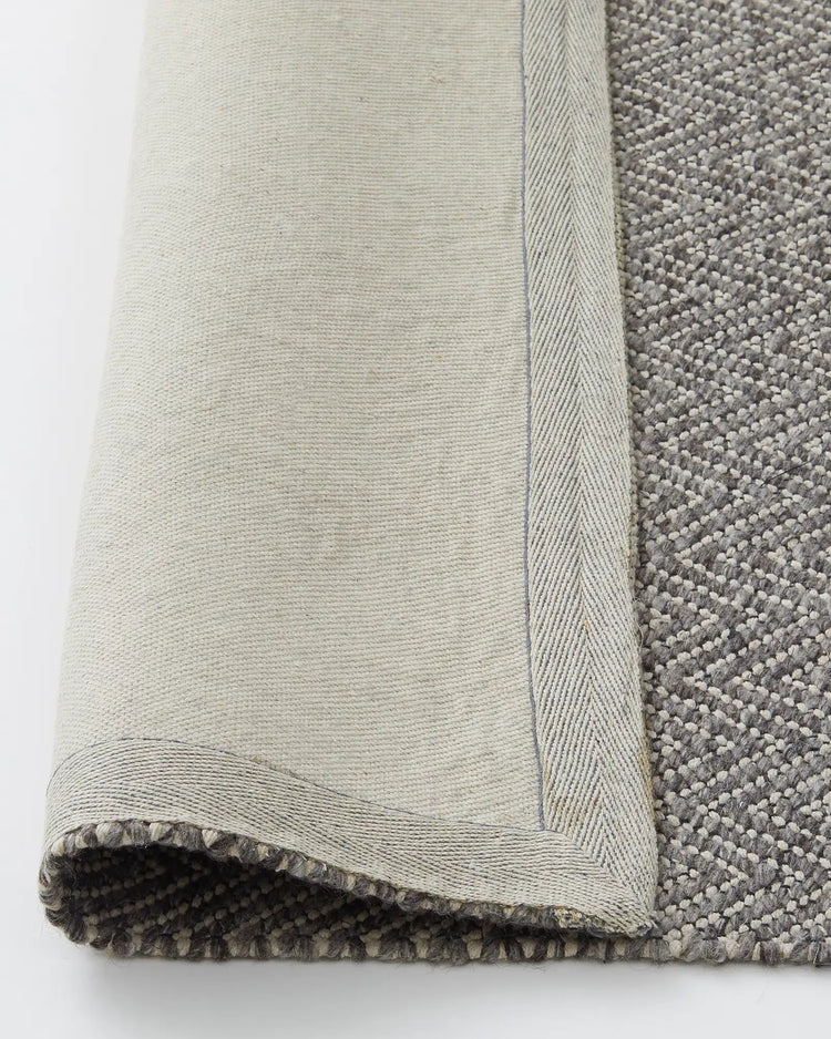 Matterhorn Tar rug detail showing wool-cotton blend chevron weave, cotton braided edge and backing by Weave Home