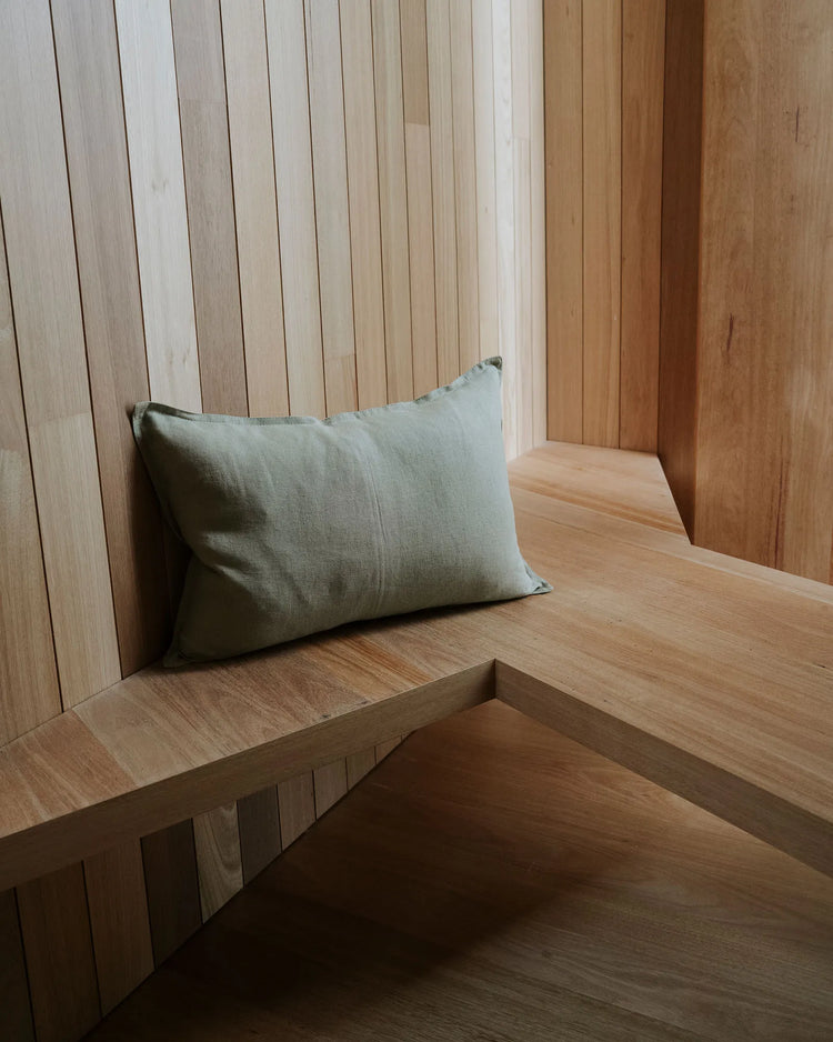Como Willow linen cushion in soft green, lumbar size, on wooden bench by Weave Home