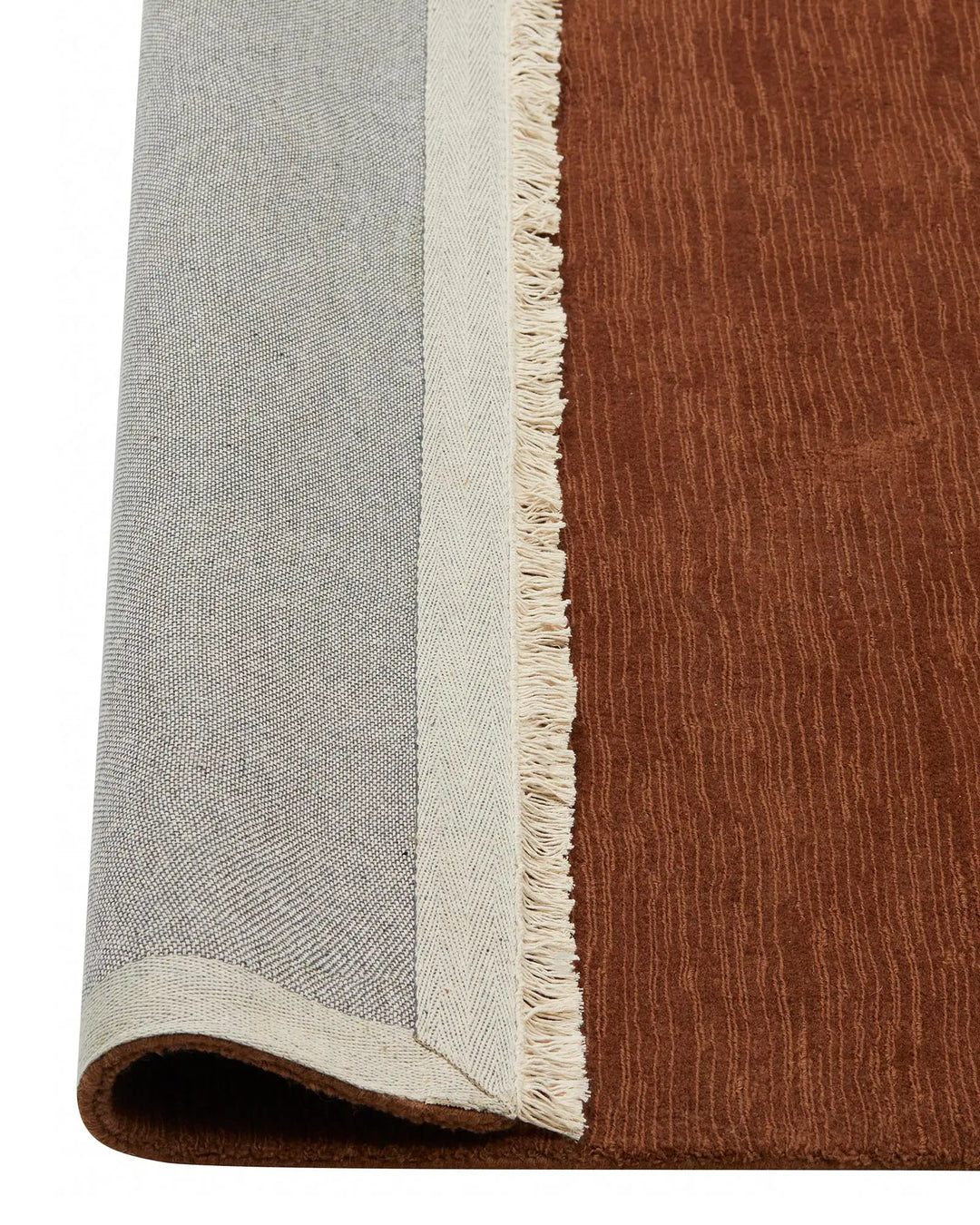 Alessandre Clay low-traffic rug in warm red-brown wool with cream fringe edge and cotton backing, detail view by Weave Home
