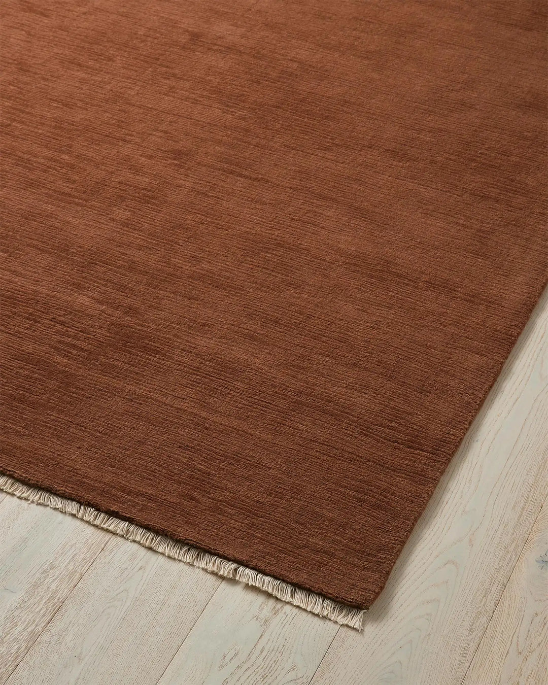 Alessandre Clay rug corner detail, warm red-brown hand-woven NZ wool with cotton backing by Weave Home