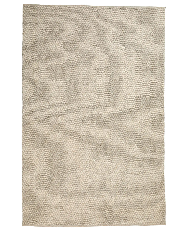 Zambesi Sandstorm wool blend rug in natural beige with tightly woven chevron pattern and cotton braided edge by Weave Home