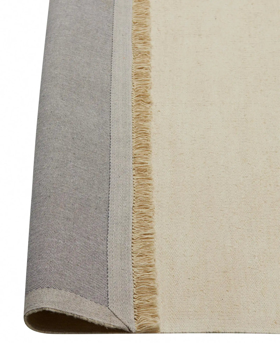 Emilio Canvas linen rug detail, showing cream flat-weave texture with natural jute fringe border by Weave Home