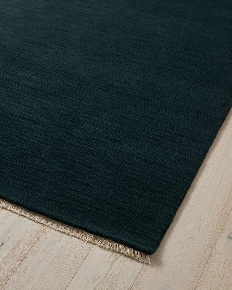 Alessandre Dusk rug corner detail, hand-woven NZ wool with cream fringe border on light wood floor by Weave Home