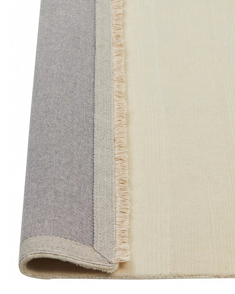 Alessandre Seasalt rug detail, hand-woven NZ wool in cool-tone ivory with herringbone weave and fringe border by Weave Home