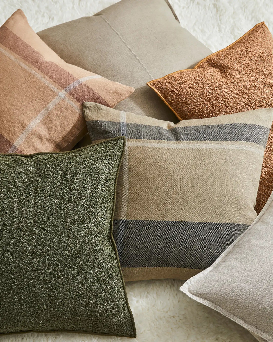 Dante Caper cushion in soft green linen with placement check pattern, styled with coordinating earth-tone pillows by Weave Home