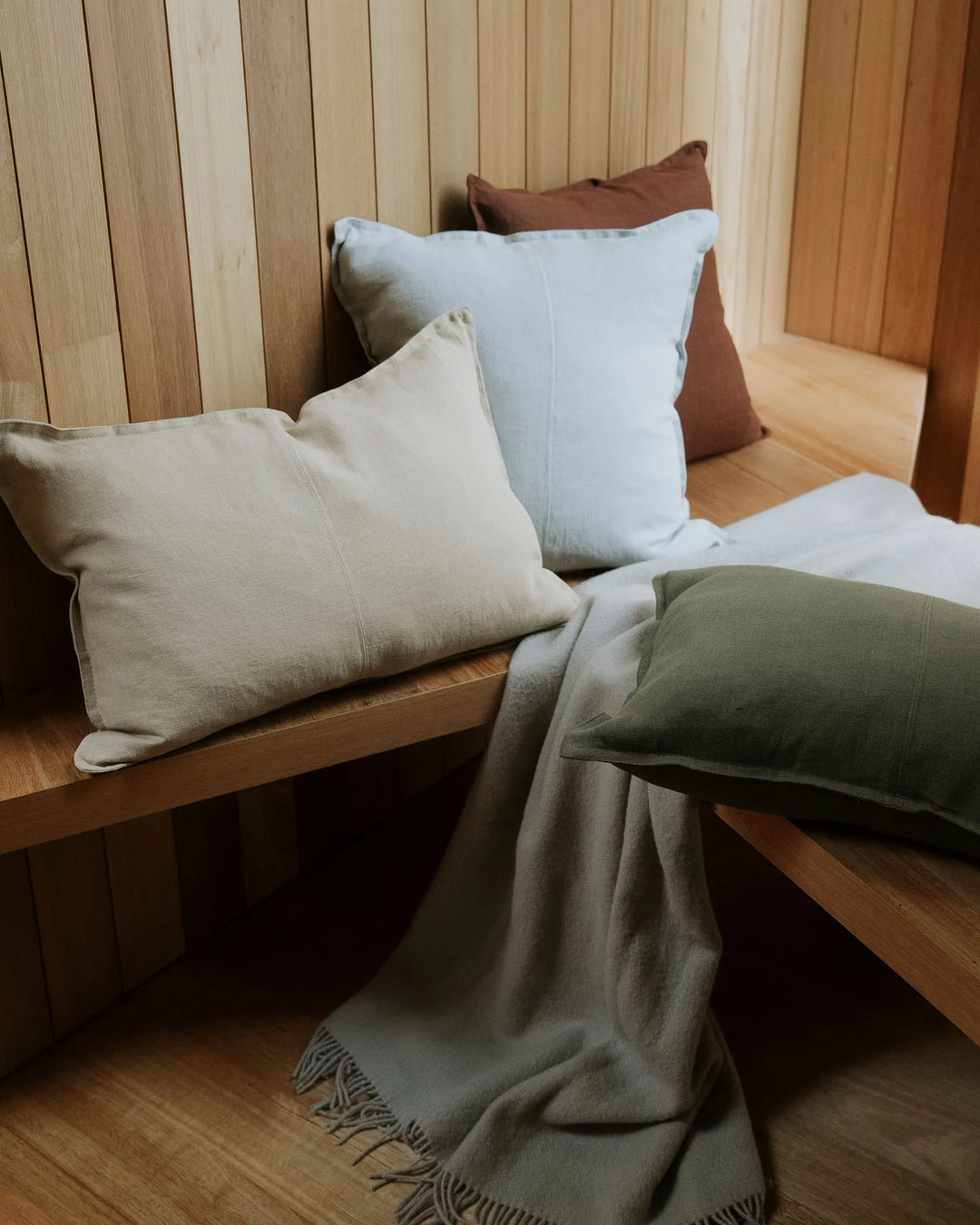 Como Oatmeal 50x50 European Linen cushion, stonewashed for soft vintage texture, displayed on wooden bench by Weave Home