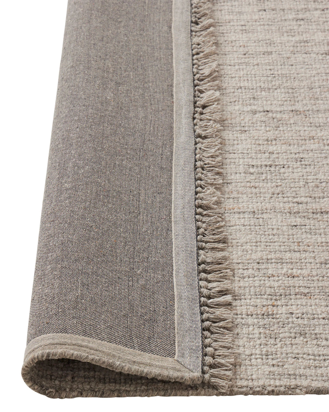 Puglia Fox rug detail showing chunky woven texture and fringed edge in ivory with grey tones by Weave Home