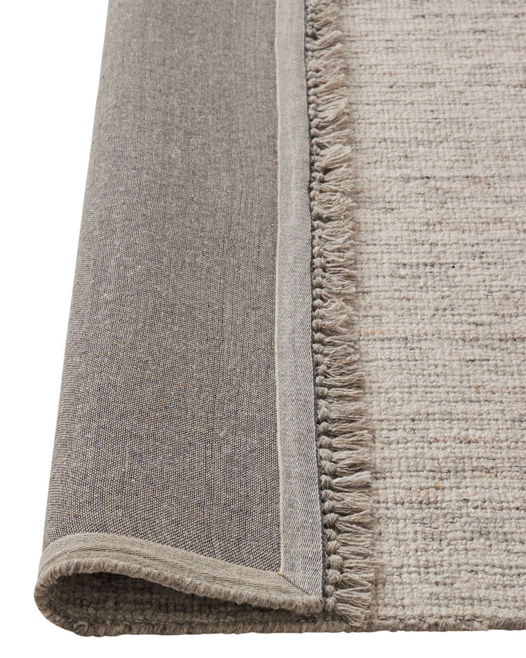 Puglia Fox rug detail showing chunky woven texture and fringed edge in ivory with grey tones by Weave Home