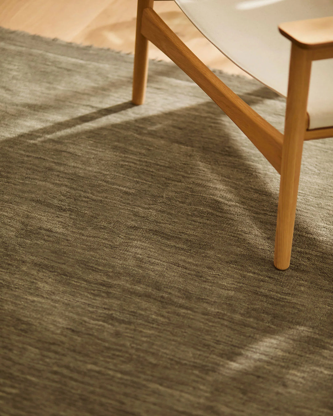 Silvio Flint rug in warm grey, hand-woven with micro fringe border detail, styled in modern living space by Weave Home