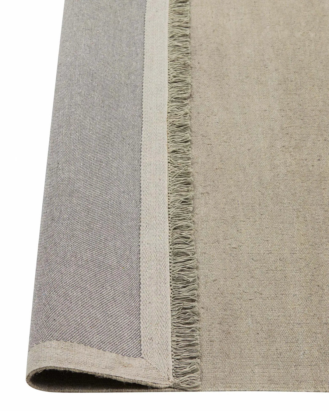 Emilio Oyster linen rug detail view, showing fringe border and flat-weave texture in pale grey by Weave Home