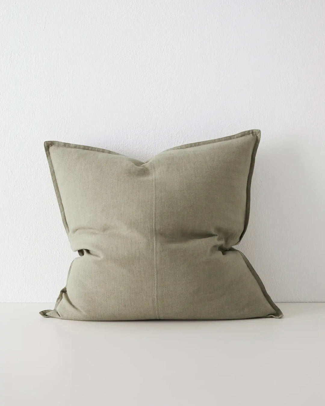 Como Caper 60x60 linen cushion in soft muted green with tailored piping edge detail by Weave Home