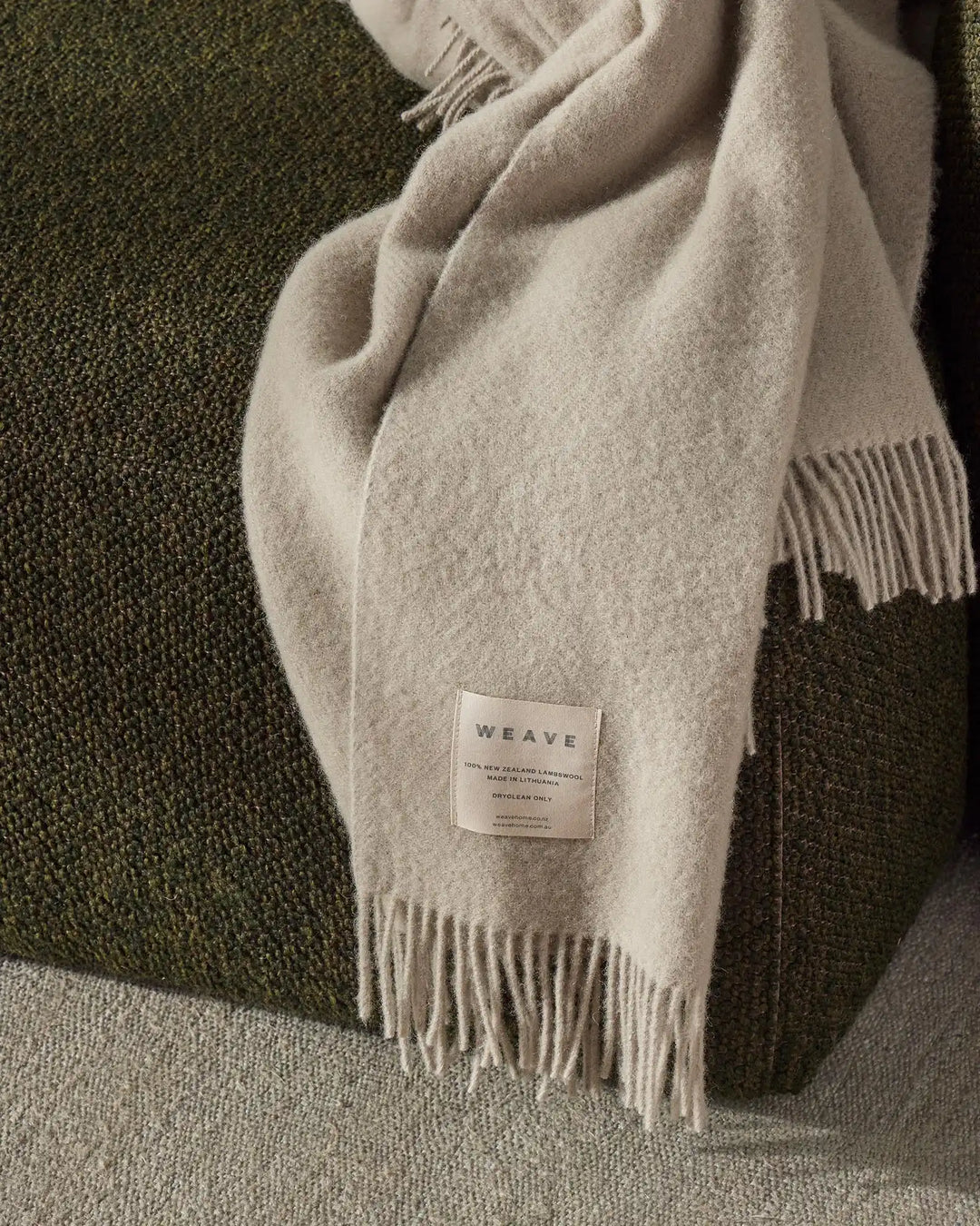 Nevis Limestone lambswool throw with tassel fringe border, detail view of texture and woven construction by Weave Home