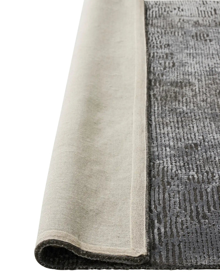 Glebe Shadow rug corner detail showing charcoal viscose-blend weave with cotton backing and edging by Weave Home