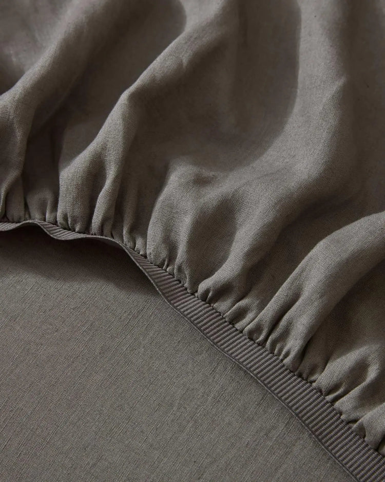 Ravello Fitted Sheet in Charcoal, close-up of elastic edge detail and soft European linen weave by Weave Home