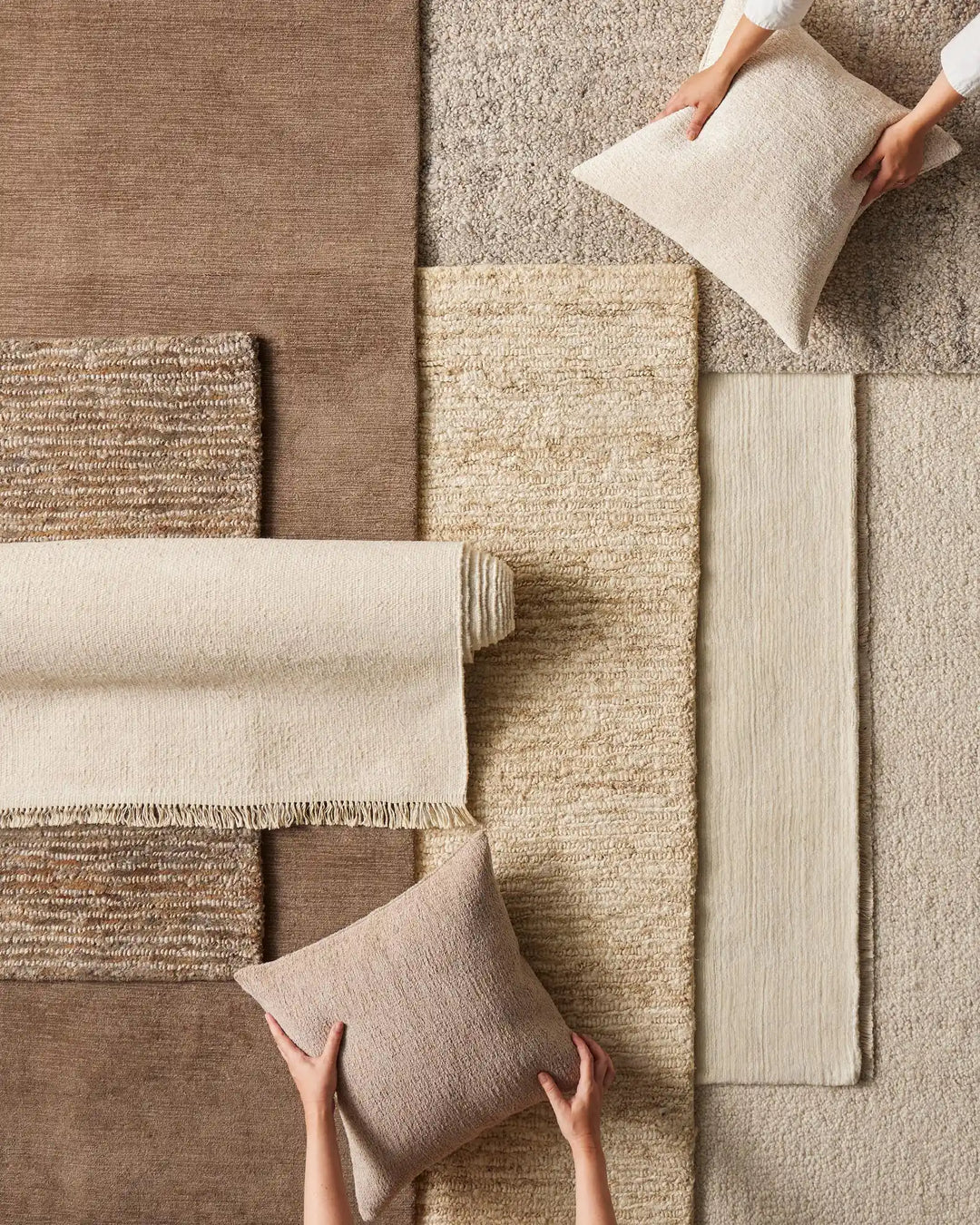 Neutral textile mood board featuring layered woven rugs, throws and cushions in cream, taupe and natural jute tones, displaying texture and material variety from everyday home styling.