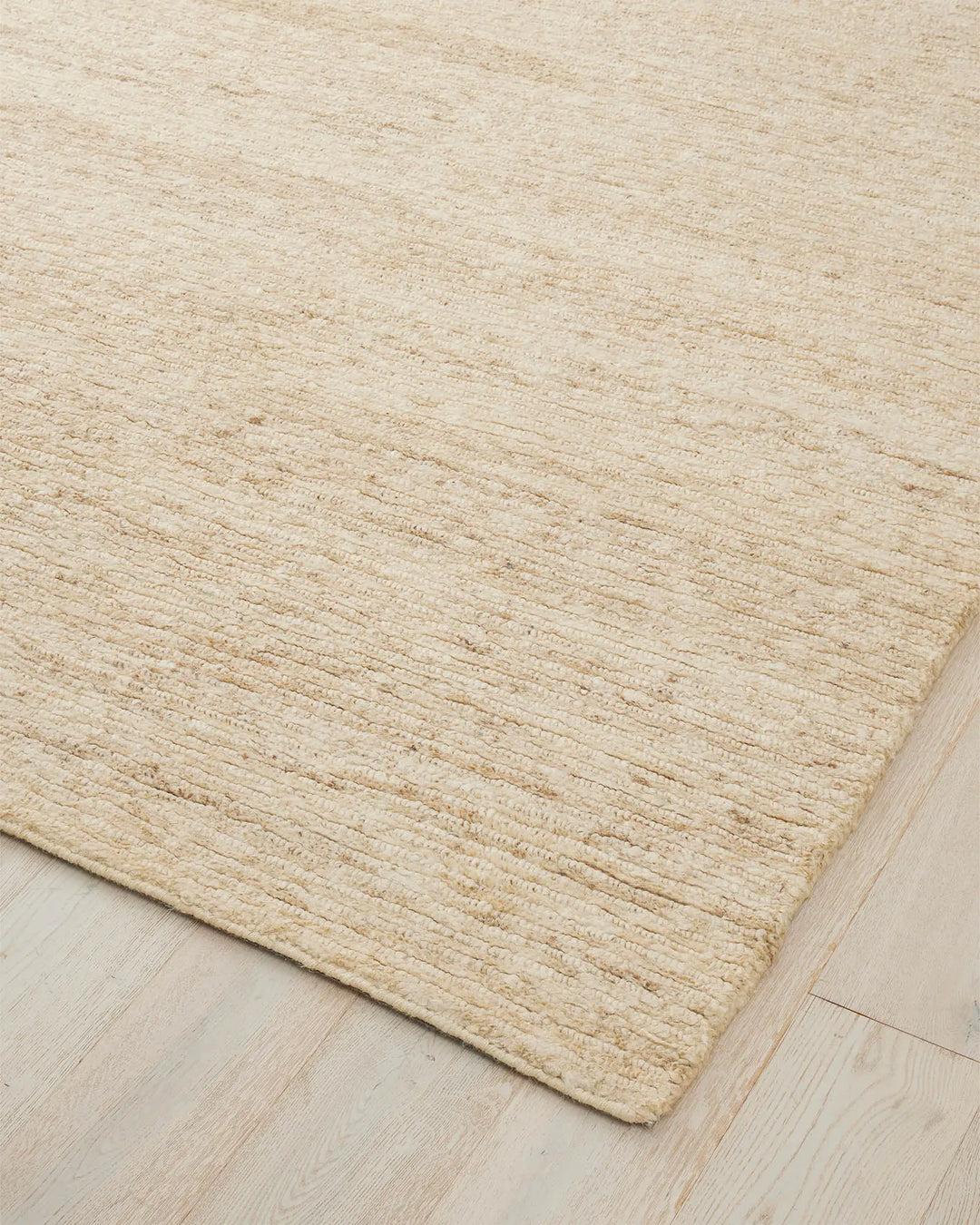 Bastian Macadamia jute rug corner detail, showing textured linear weave in creamy neutral tone by Weave Home