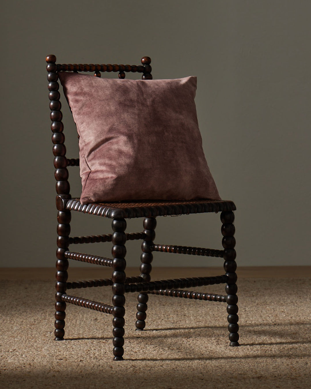 Ava Dusk 50x50cm velvet cushion in soft purple with pink undertones, styled on wooden chair by Weave Home