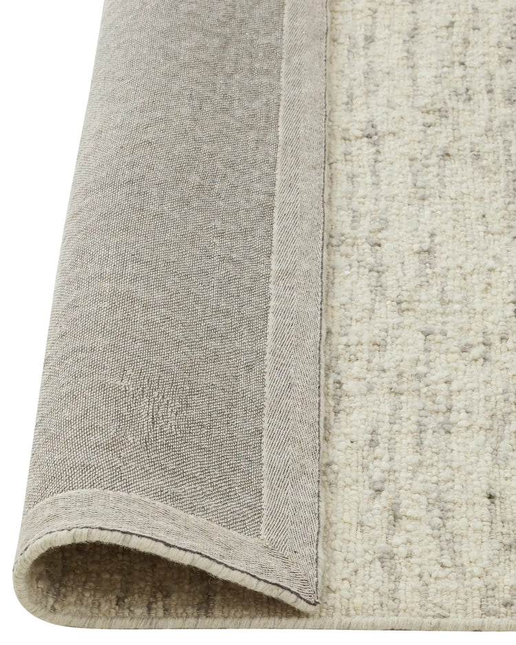 Henley Pelican rug backing detail, NZ wool bouclé weave in ivory with grey tones, bound edge visible by Weave Home