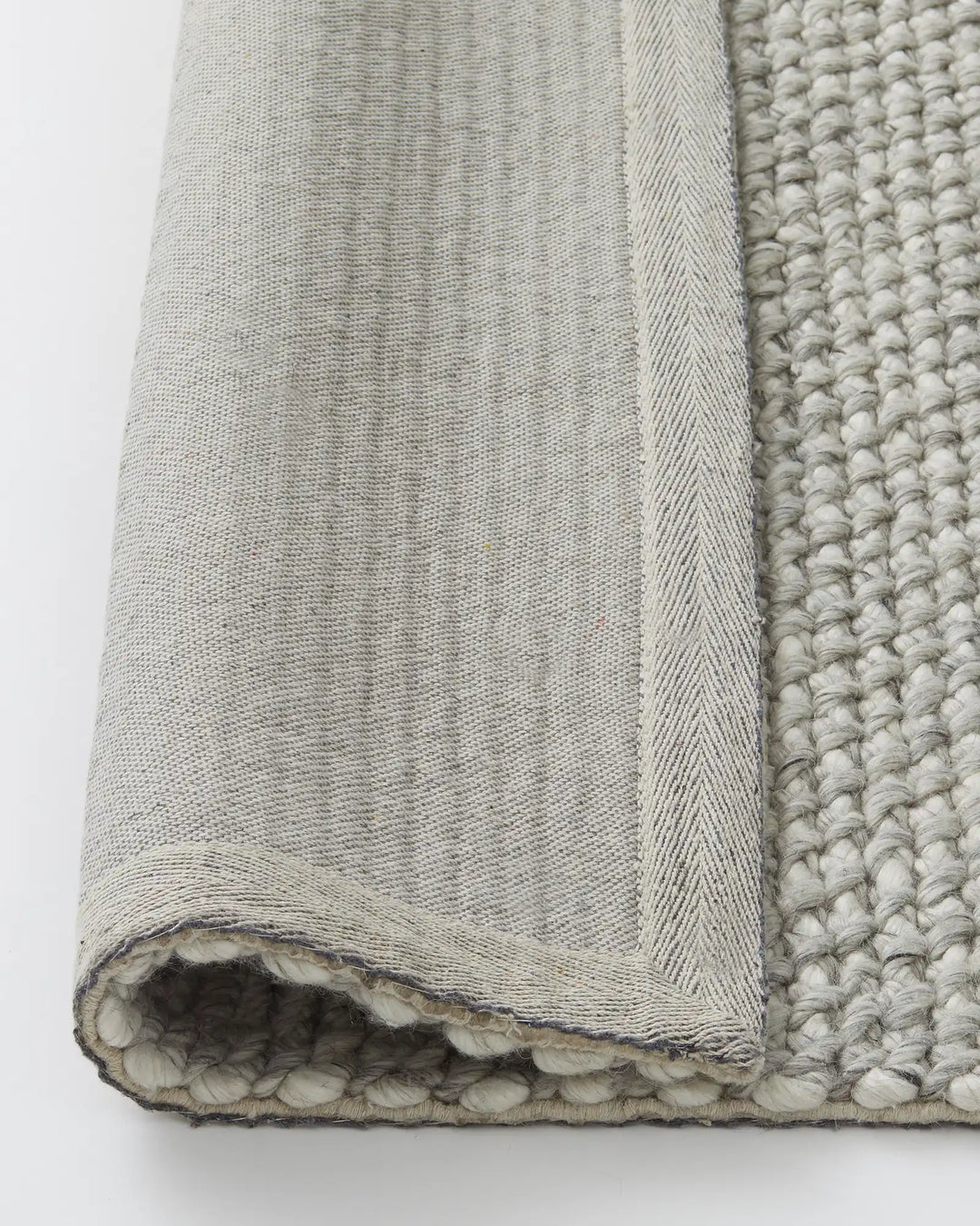 Emerson Feather rug close-up detail shot showing chunky woven NZ wool texture and charcoal-stitched backing by Weave Home