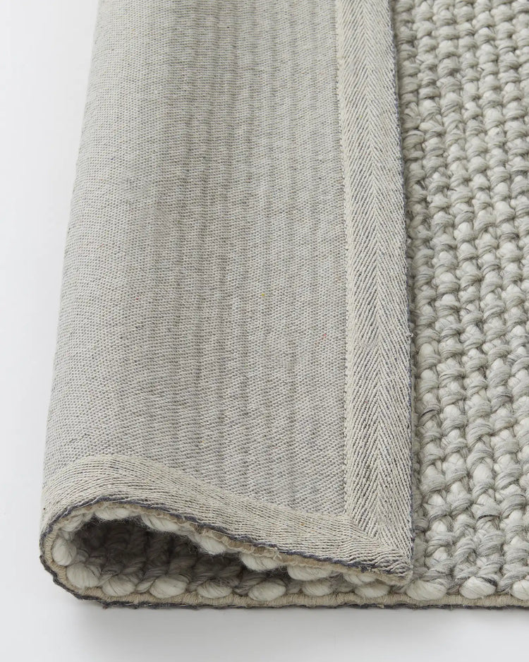 Emerson Feather rug close-up detail shot showing chunky woven NZ wool texture and charcoal-stitched backing by Weave Home