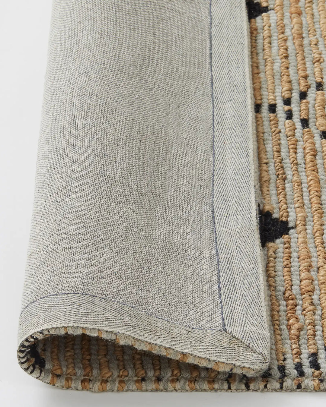 Denali Sandstorm rug backing detail, showing jute weave and cotton braided edge by Weave Home