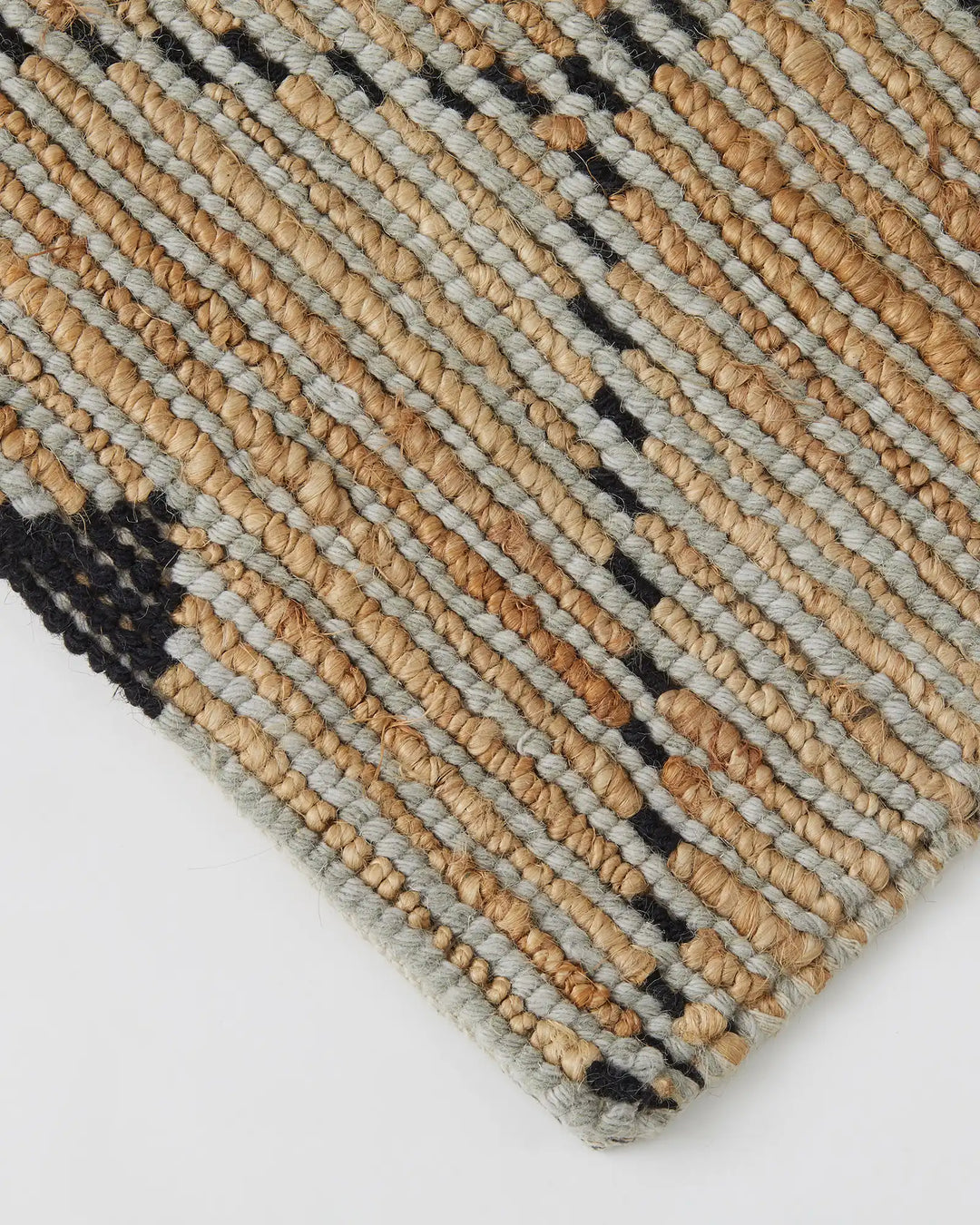 Denali Sandstorm rug detail shot showing hand-woven jute with geometric diamond pattern in natural tan, grey, and black by Weave Home