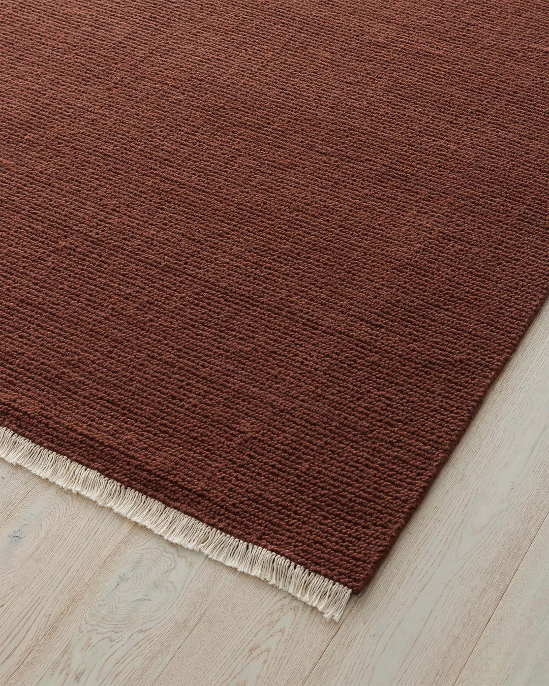 Fabien Ember rug detail, burgundy wool with ribbed weave texture and cream fringe border by Weave Home
