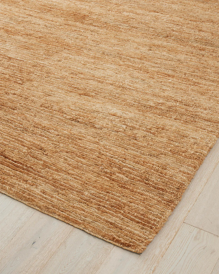 Bastian Natural jute rug corner detail showing linear looped and cut weave texture in golden-brown, by Weave Home