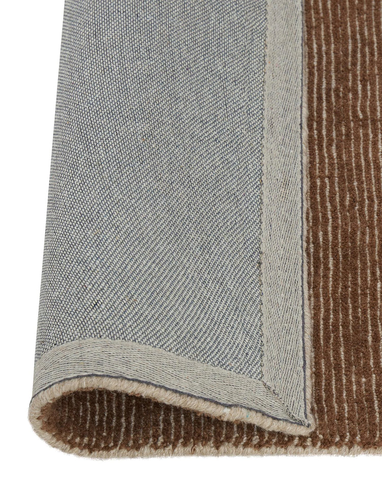 Remo Amber wool rug detail showing copper and beige striped weave with beige border, textured NZ wool construction by Weave Home