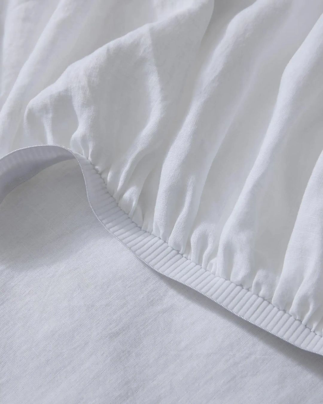 Ravello Fitted Sheet in white European linen, detail of elastic edge with blanket stitch seam by Weave Home