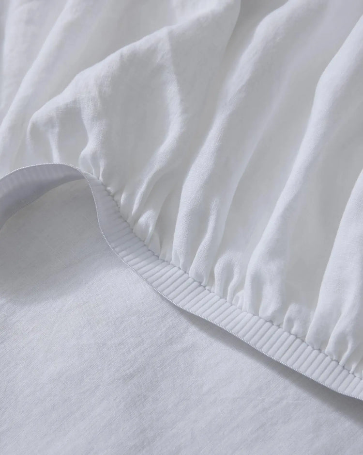 Ravello Fitted Sheet in white European linen, detail of elastic edge with blanket stitch seam by Weave Home