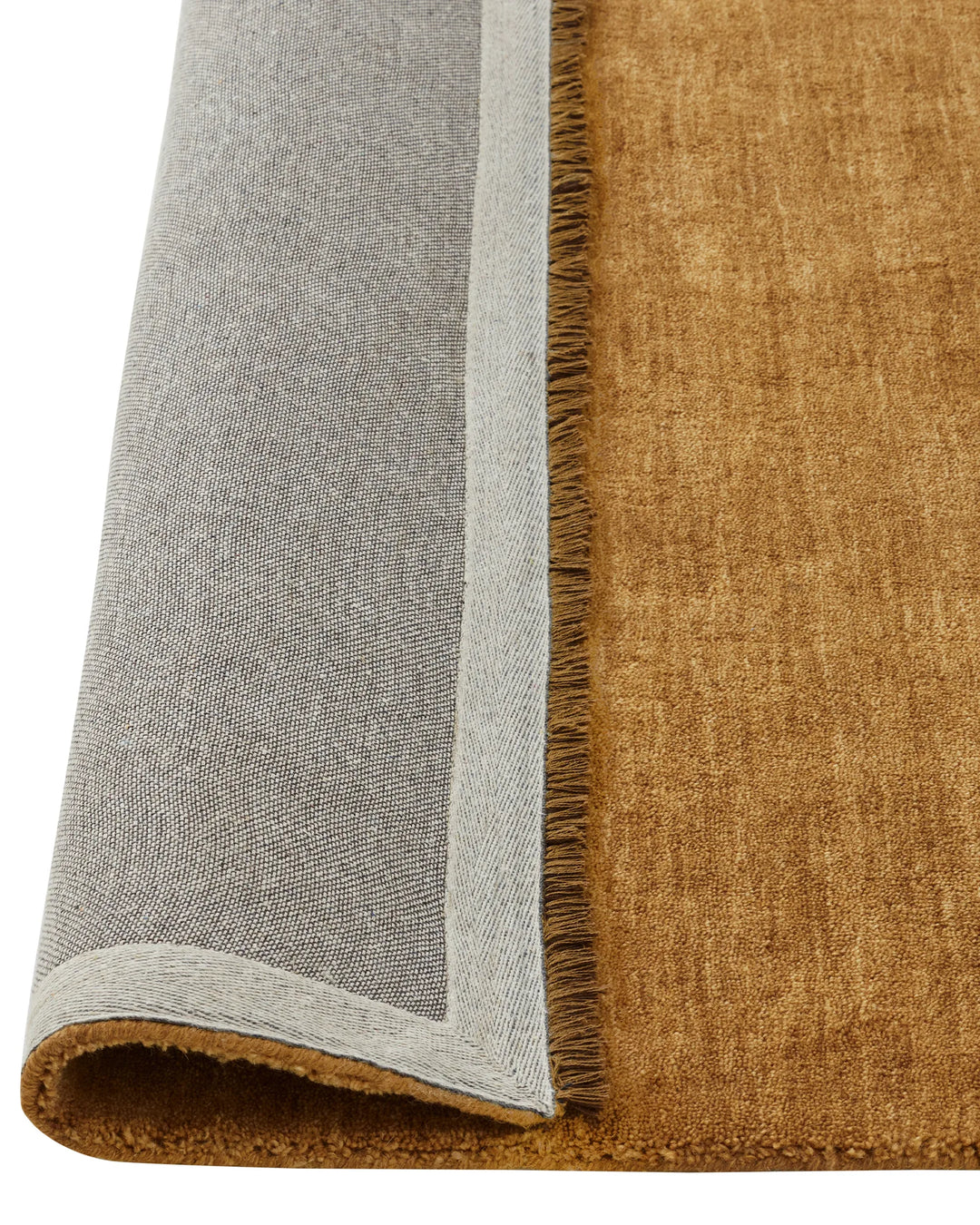 Silvio Dijon rug detail showing mustard wool pile with grey binding and micro fringe border, sustainable styling by Weave Home