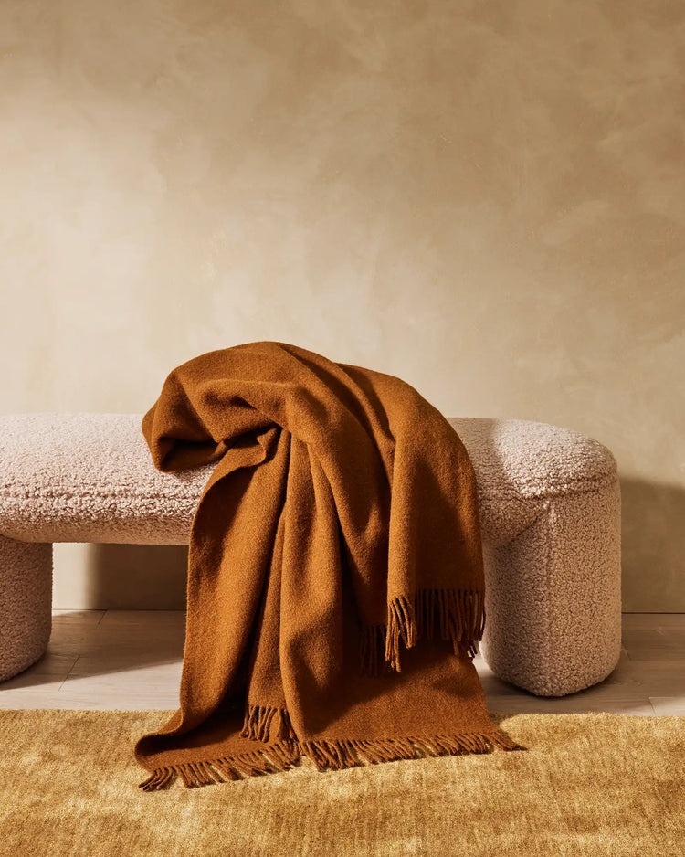 Silvio Dijon hand-woven rug in mustard yellow with micro fringe border detail, draped over neutral bench by Weave Home