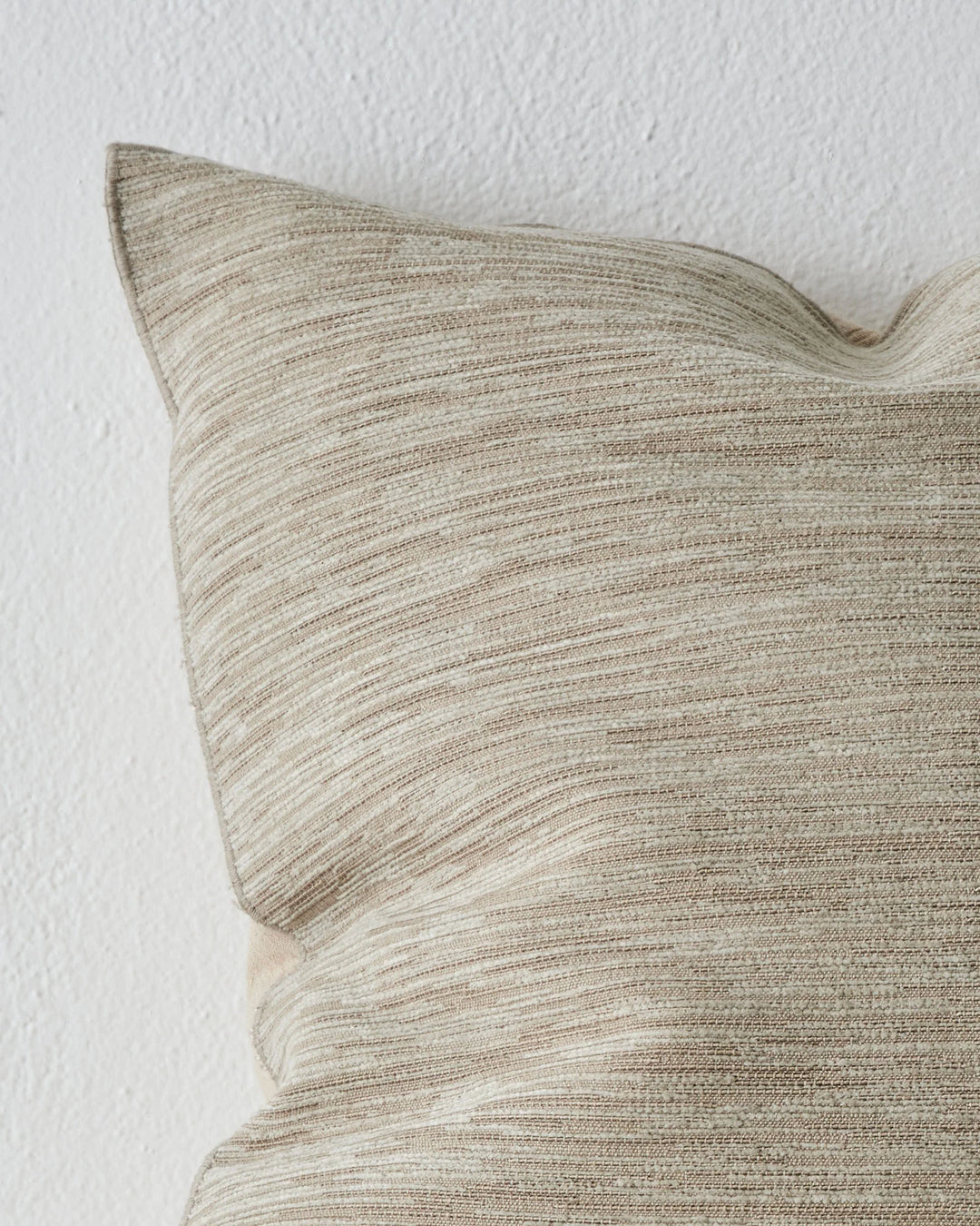 Dania Oyster cushion cover detail, showcasing woven texture and warm two-toned colourway with metallic highlights, by Weave Home