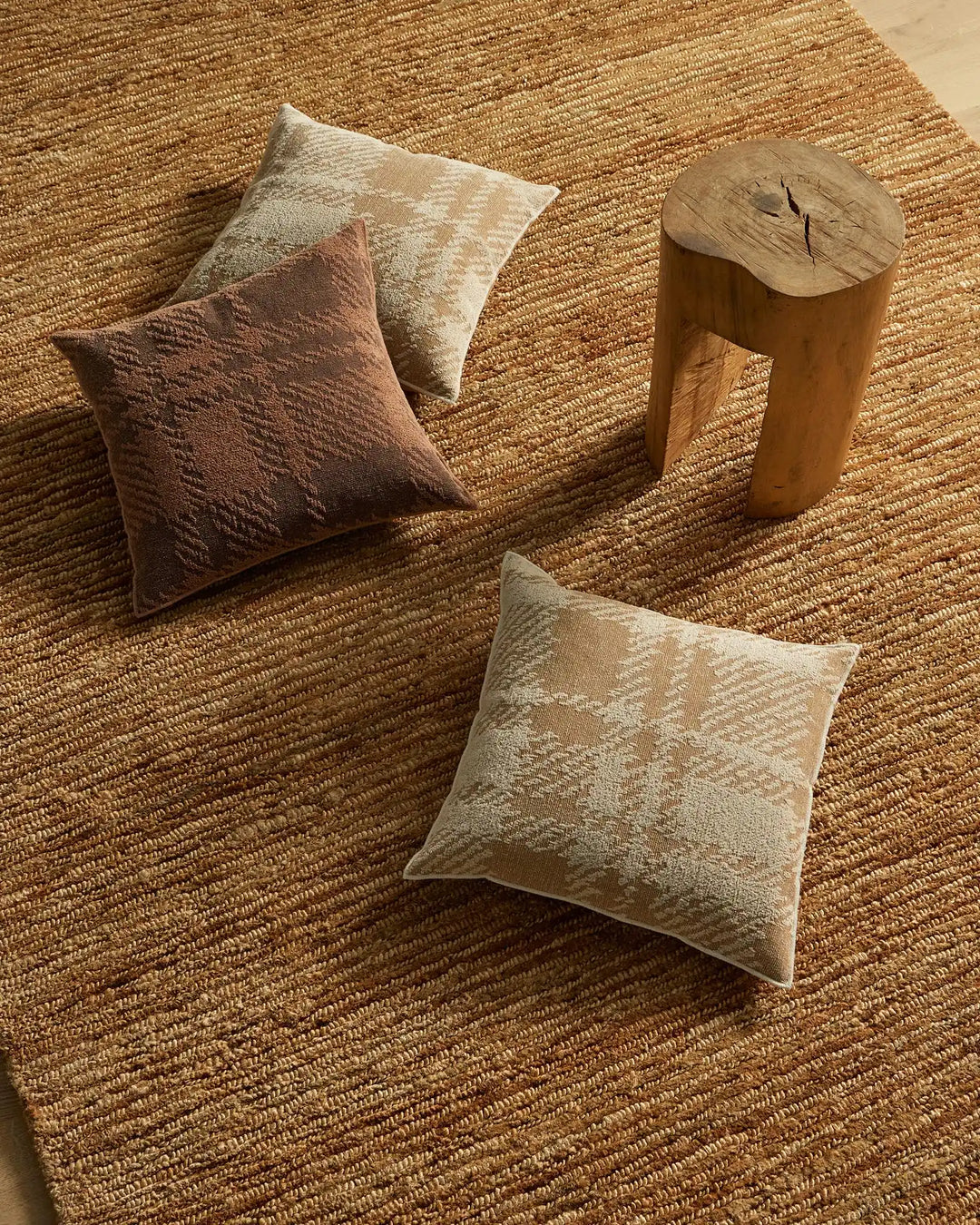 Sienne Earth cushion in reddish-brown polyester cotton blend with oversized check design, overlocked edge detail, on natural jute rug by Weave Home